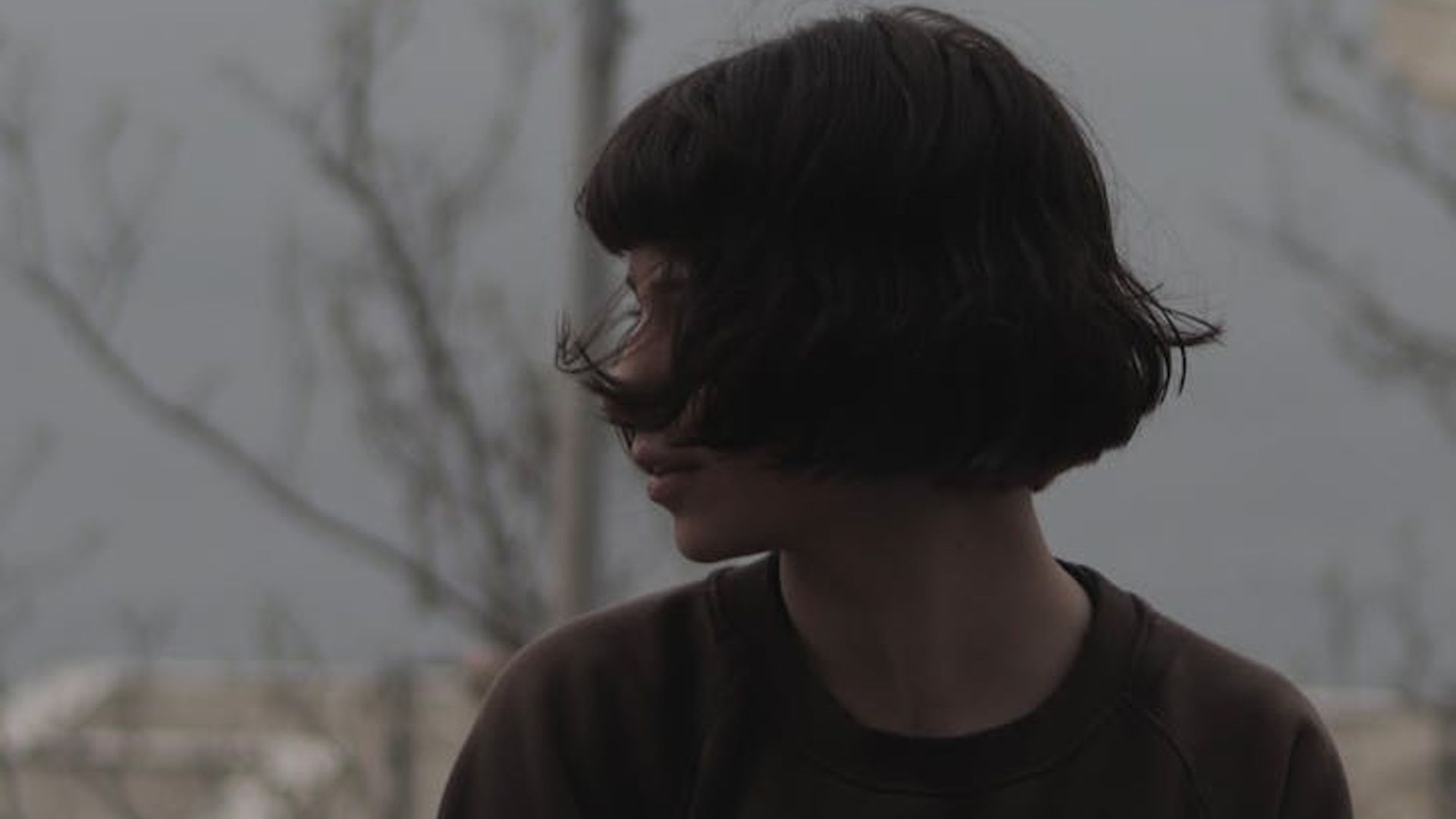 Silhouette of a woman in a dynamic yet calm pose against a soft background.